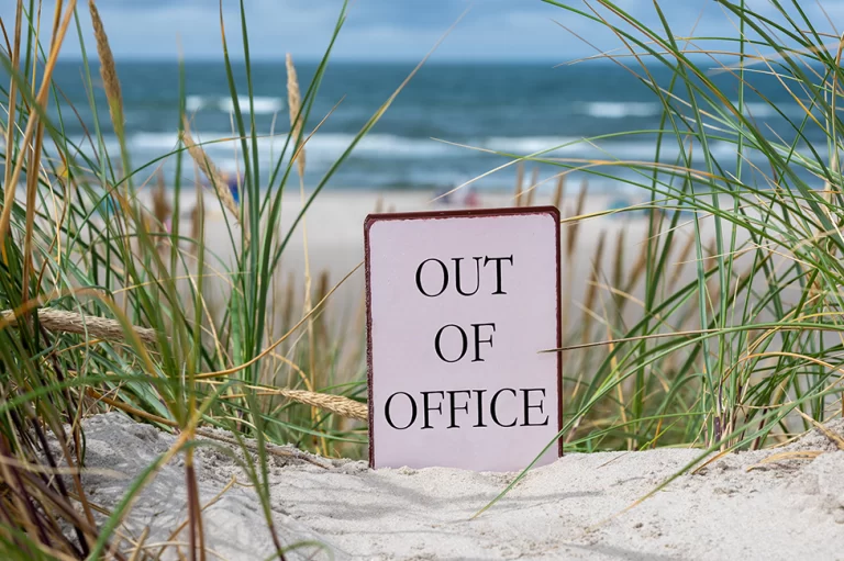 Een bordje "out-of-office" in de duinen bij het strand